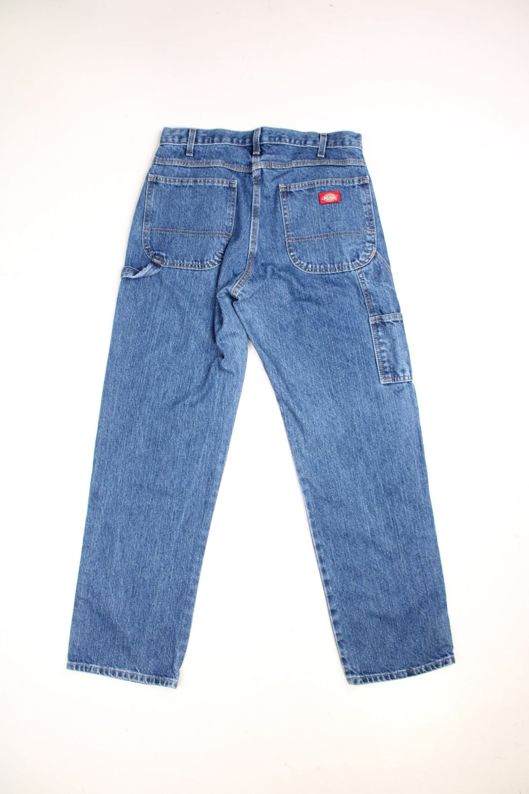  Carpenter Jeans in a dark  colourway, has multiple pockets, and the logo embroidered on the back.