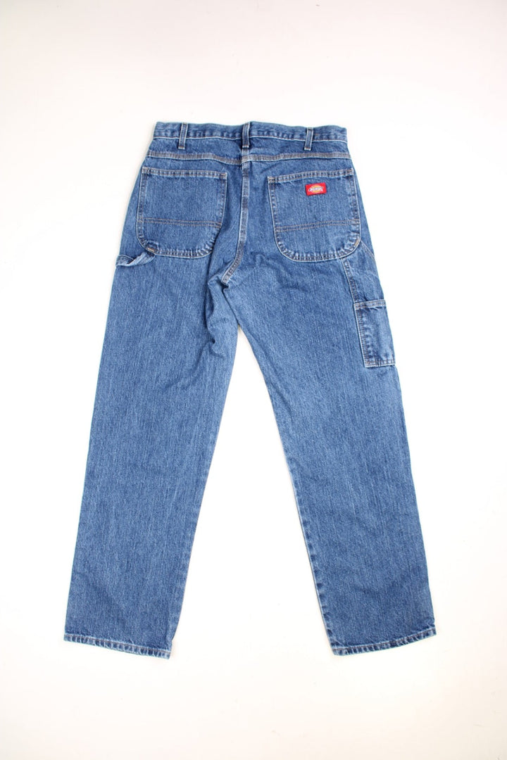  Carpenter Jeans in a dark  colourway, has multiple pockets, and the logo embroidered on the back.