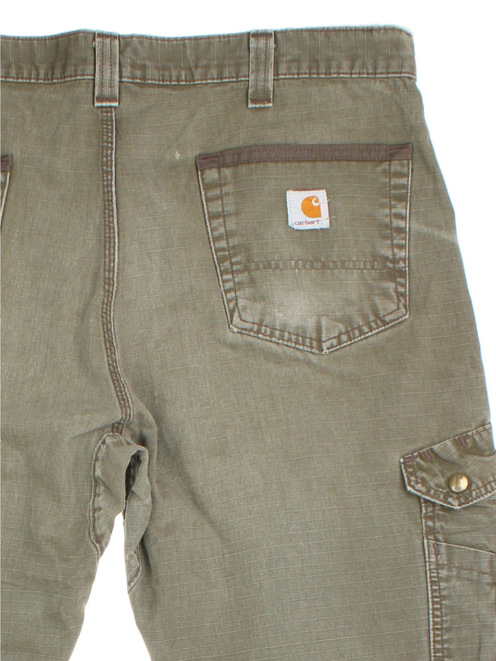 Carhartt Cargo Trousers in a green colourway with multiple pockets and the logo embroidered on the back.