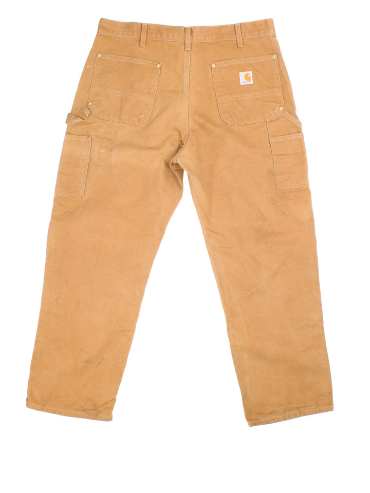 Carhartt Double Knee Jeans in tan colourway with multiple pockets and the logo embroidered on the back.