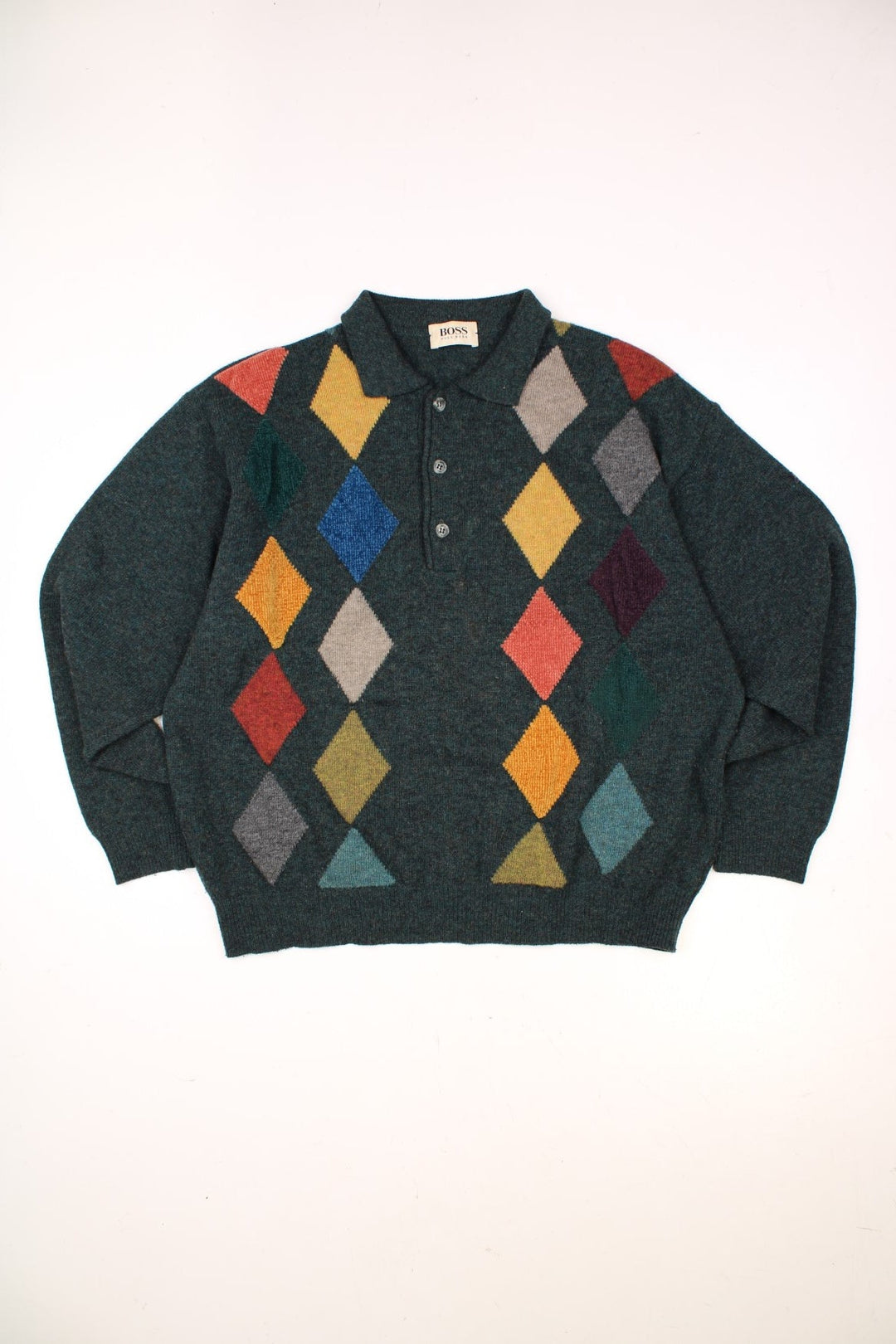 Hugo Boss Knitted Jumper in a green colourway with multicoloured diamond patterns going down the front, has a button up collar and the logo embroidered on the left sleeve. 