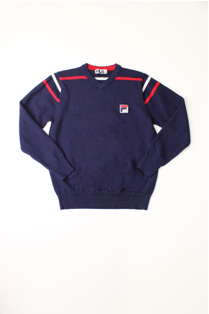 Fila navy blue knit v-neck jumper with red and white stripe detail around the shoulders. 