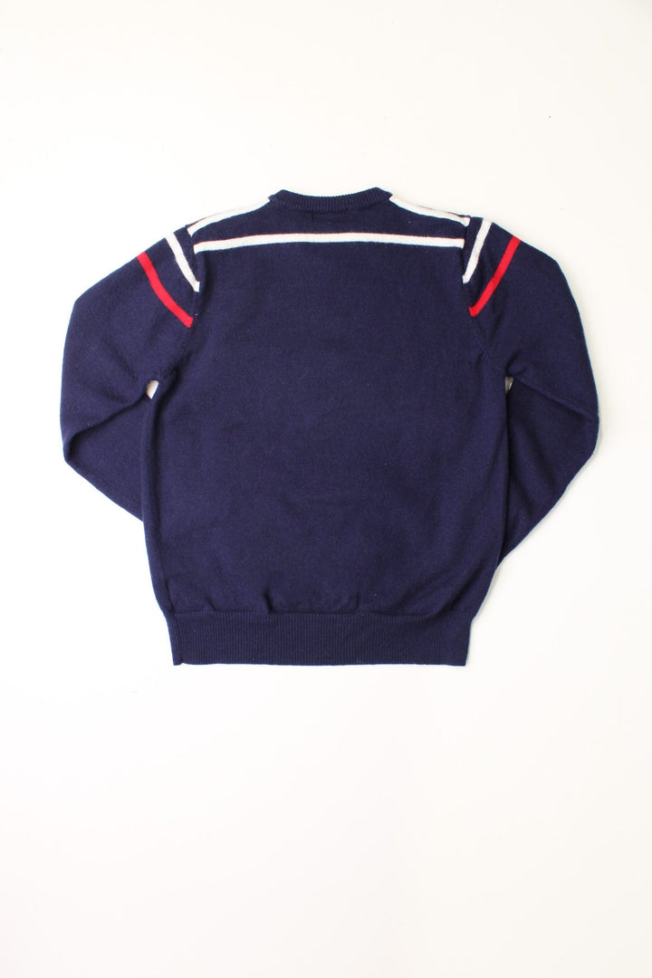 Fila navy blue knit v-neck jumper with red and white stripe detail around the shoulders.