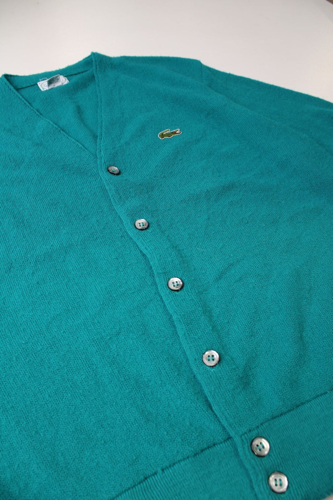 Izod Lacoste Cardigan in a turquoise colourway with the logo embroidered on the front and buttons up with a v neck collar. 