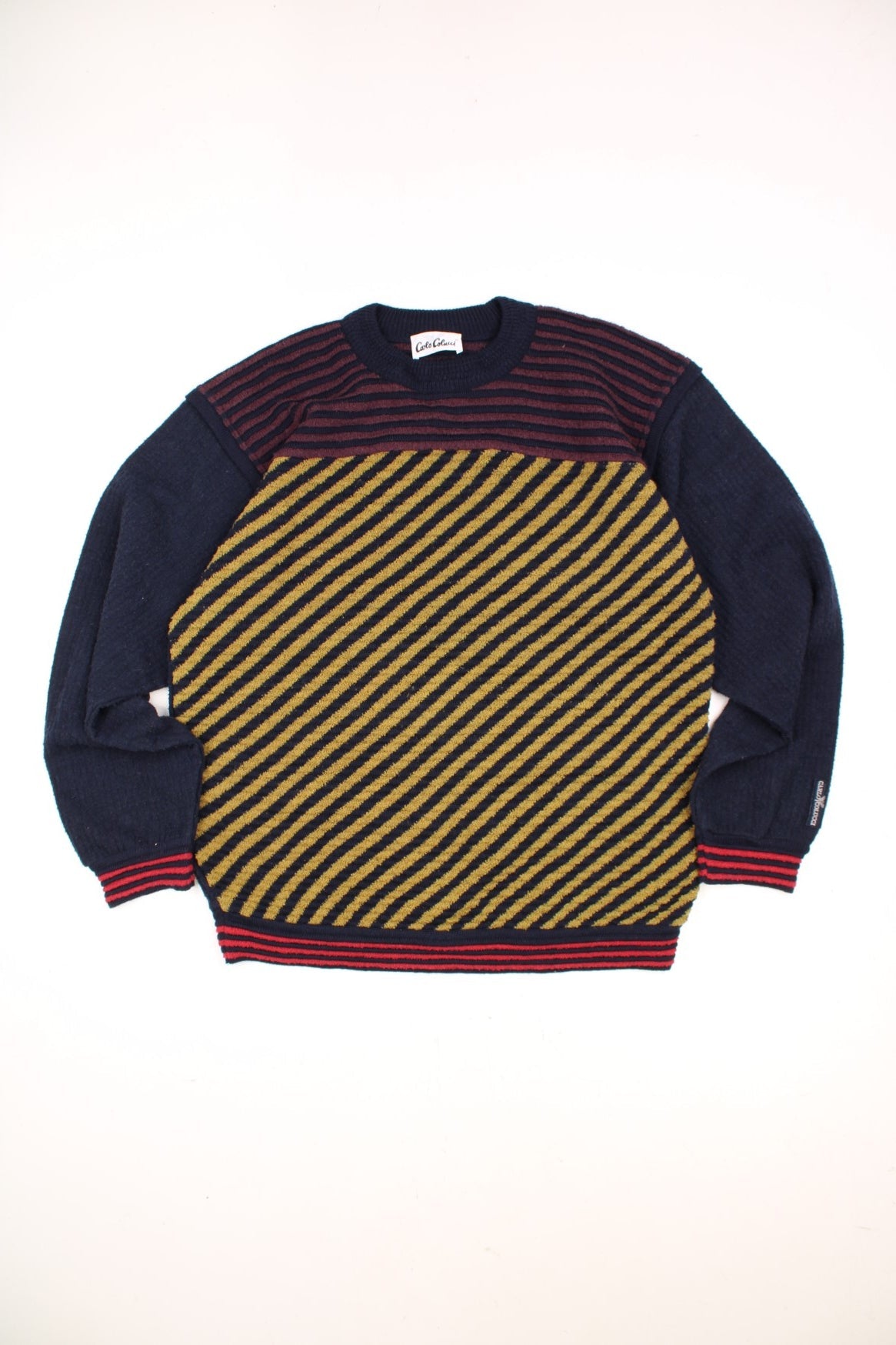 Vintage Carlo Colucci Patterned Jumper in a navy blue, red and yellow striped colourway with the logo embroidered on the left sleeve. 