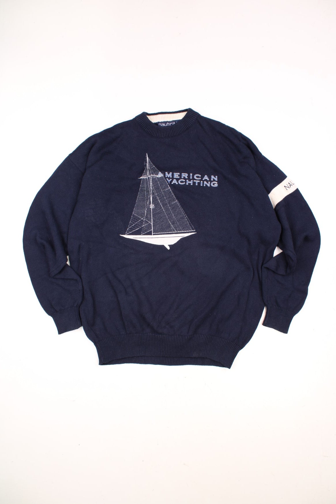 Nautica American Yachting Knitted Jumper in a navy blue and white colourway with the spell out logo and yatch graphic embroidered on the front. 