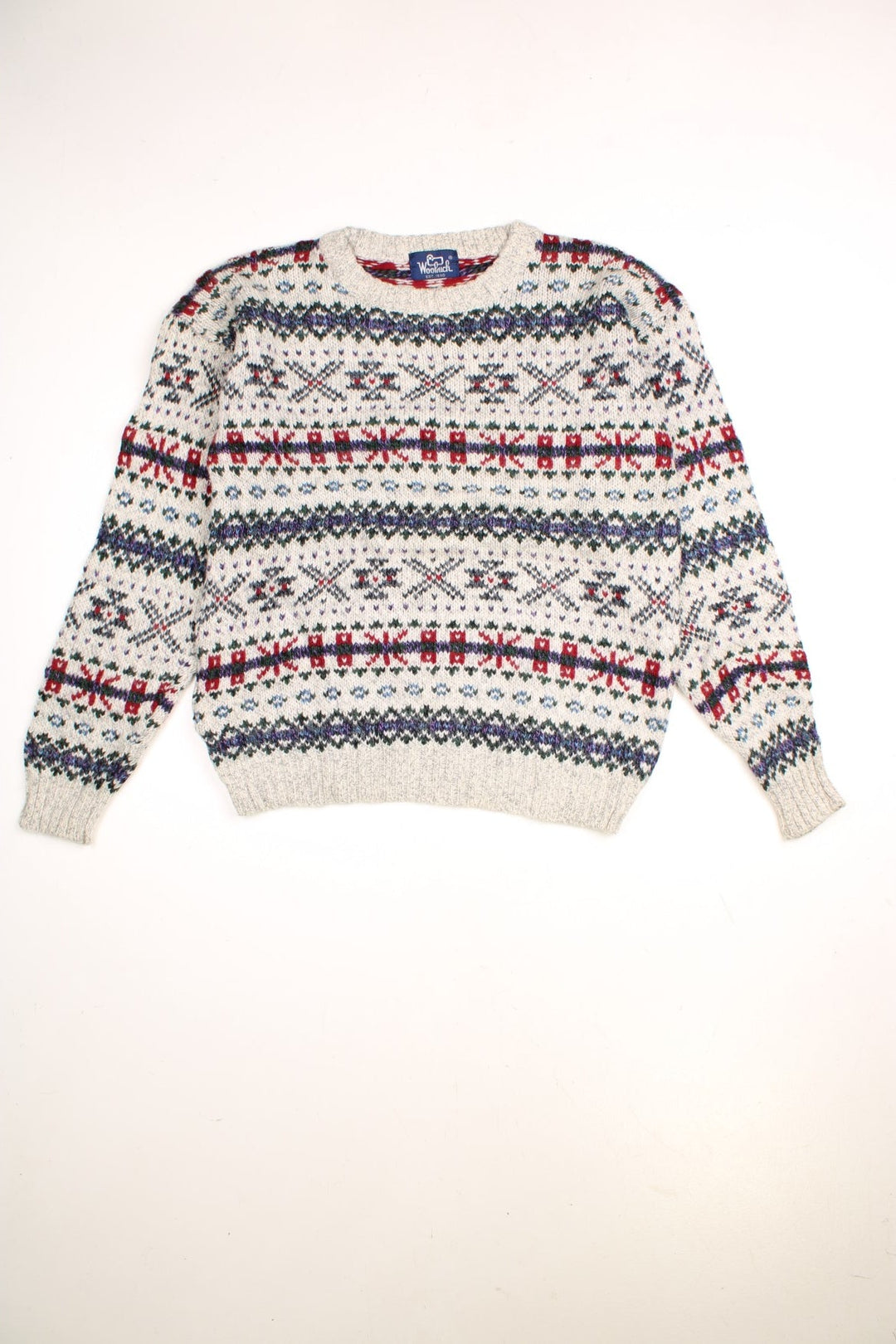 Woolrich patterned jumper in a multicoloured colourway. The knit is a grey/cream with greens reds and purplues throughout. 