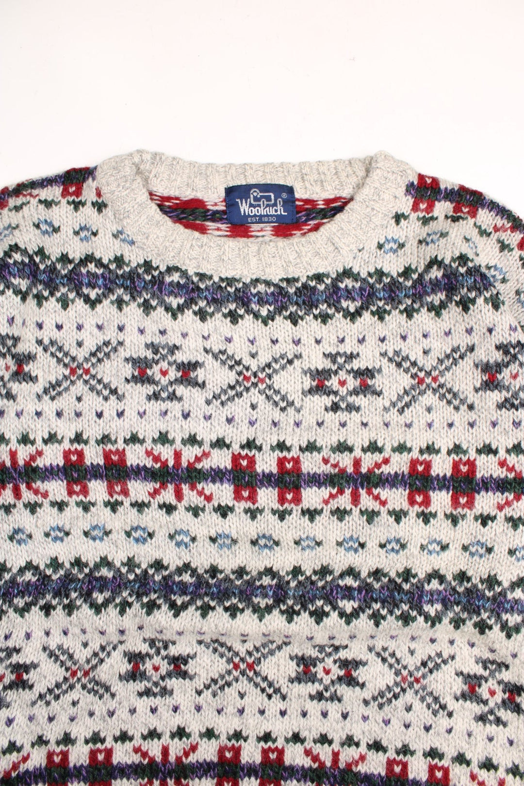 Woolrich patterned jumper in a multicoloured colourway. The knit is a grey/cream with greens reds and purplues throughout. 