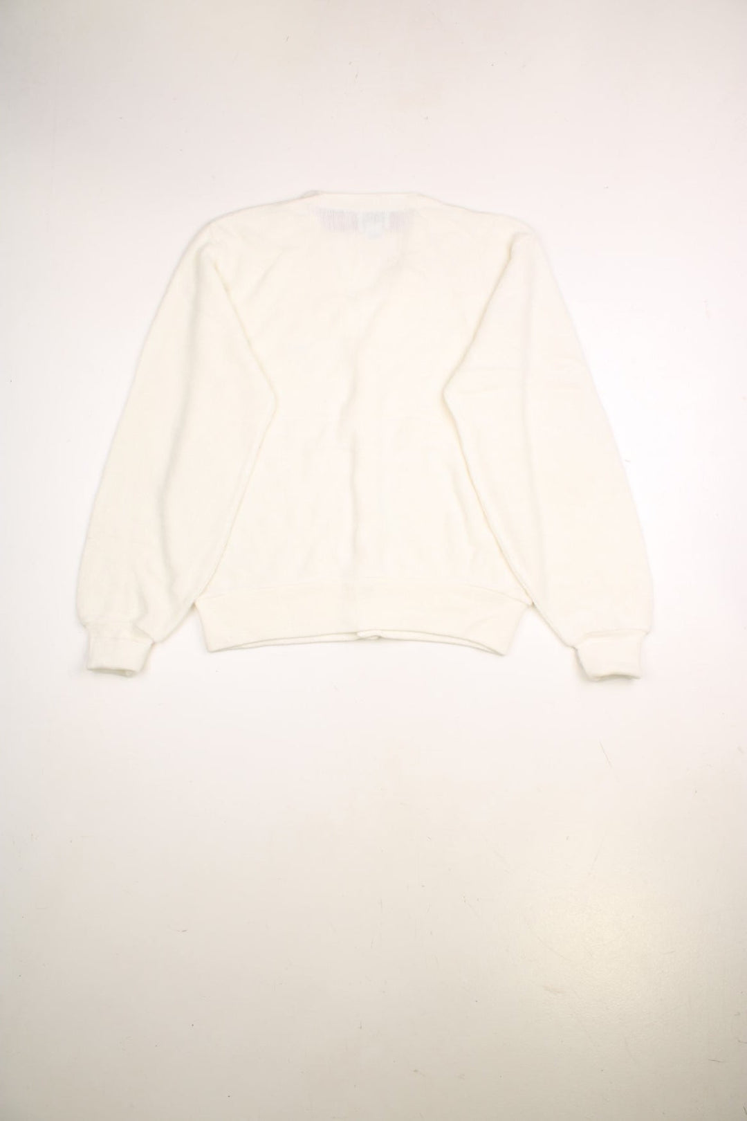 Lacoste cardigan in a off white /creamy colourway with the Lacoste logo stitched on the front. The cardigan has silvery grey buttons and cuffed sleeves. Made in USA. 