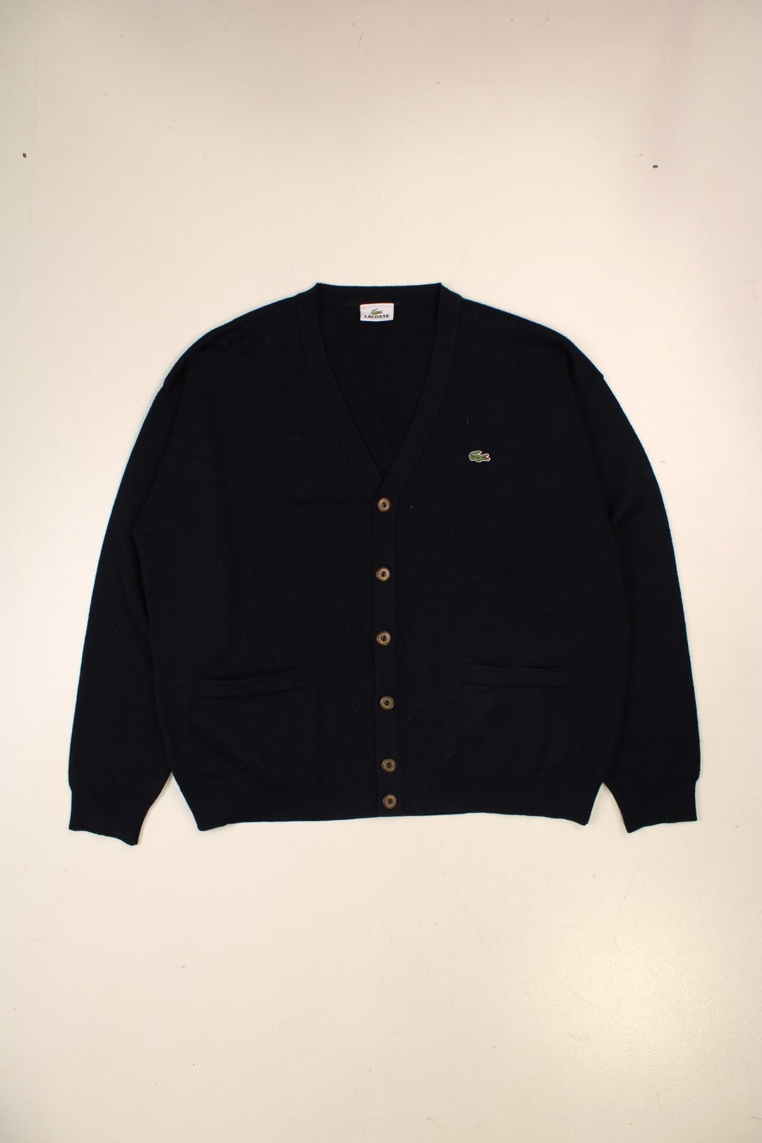 Lacoste lightweight cardigan in navy blue with brown buttons, and a crocodile logo embroidered on the front.