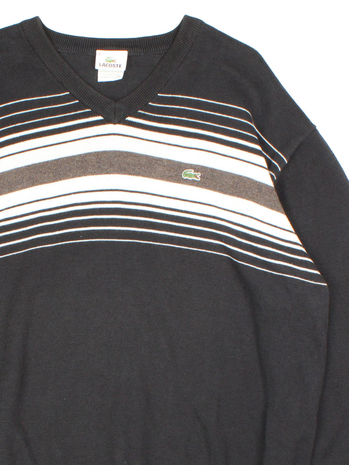 Lacoste Jumper in a black colourway with contrast white and grey stripe. V neck, with cuffed hems and embroided logo.