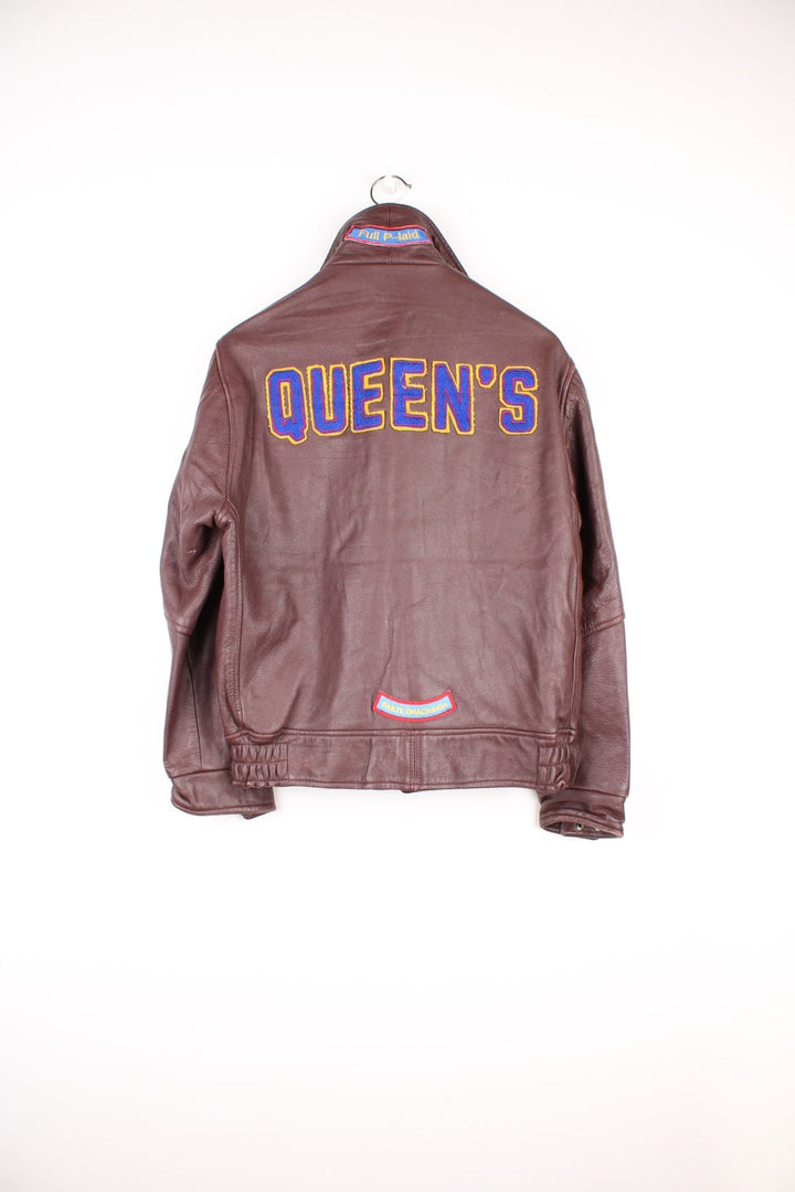 Vintage 80's Queen's University Canada Leather Varsity Jacket in a brown colourway, zip and button up, side pockets, and has the university logo and badges embroidered on throughout. 