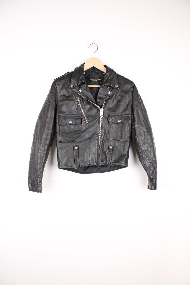 Vintage Harley Davidson Leather Biker Jacket in a black colourway, zip up with multiple pockets, insulated with a quilted lining, and has buckles on the front and back.