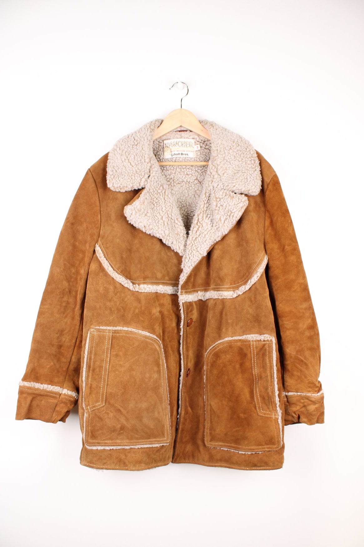 Vintage Western Schott Bros Rancher Leather Sherpa Jacket in a brown colourway with a sherpa lining, button up with a big collar, side pockets, and has cross stitching throughout.