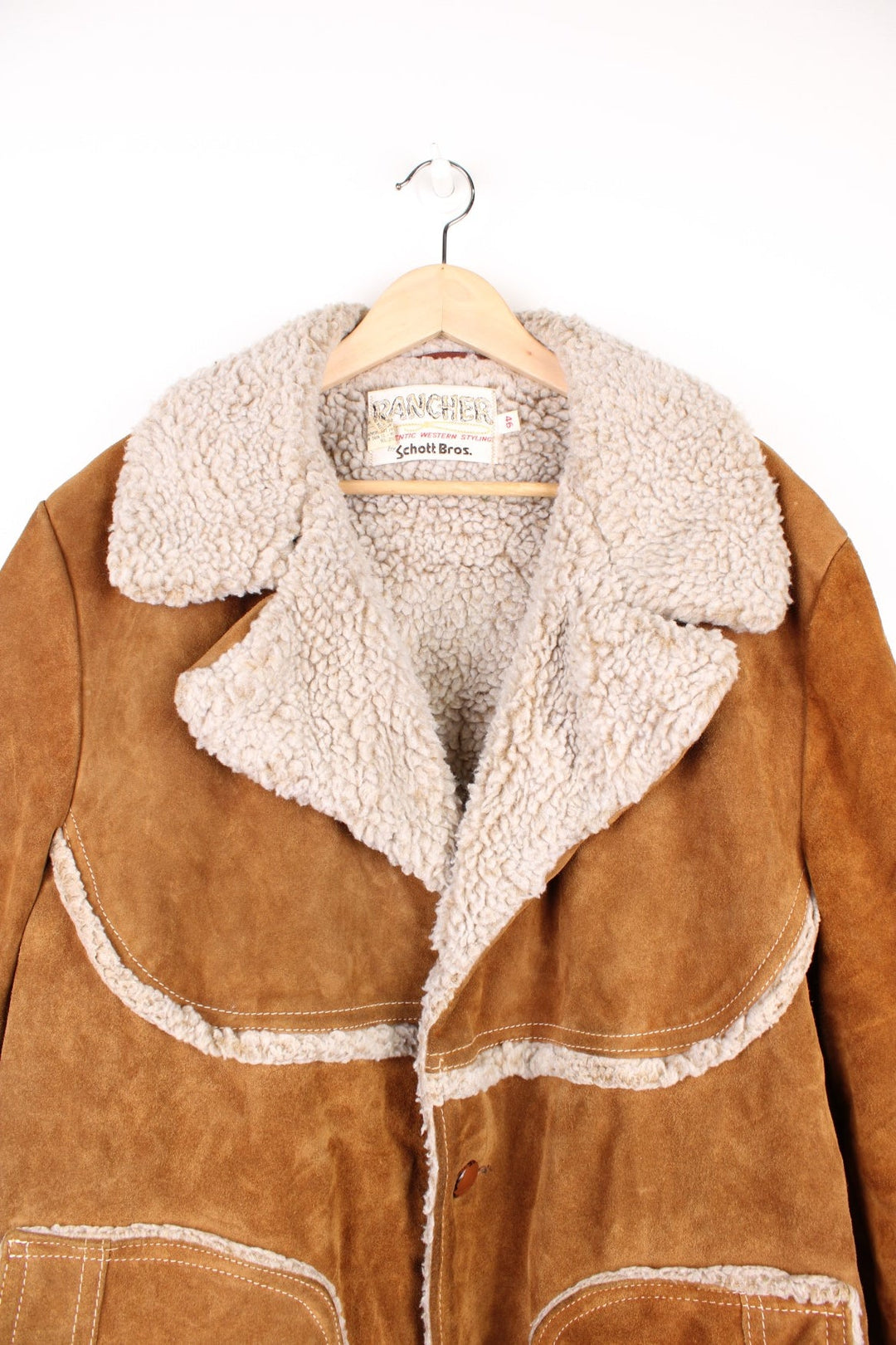 Vintage Western Schott Bros Rancher Leather Sherpa Jacket in a brown colourway with a sherpa lining, button up with a big collar, side pockets, and has cross stitching throughout.