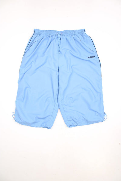 Y2K Umbro Quarter Length Shorts in a blue colourway, has an adjustable waist, mesh netted lining, side pockets, and has the logo embroidered on the front. 