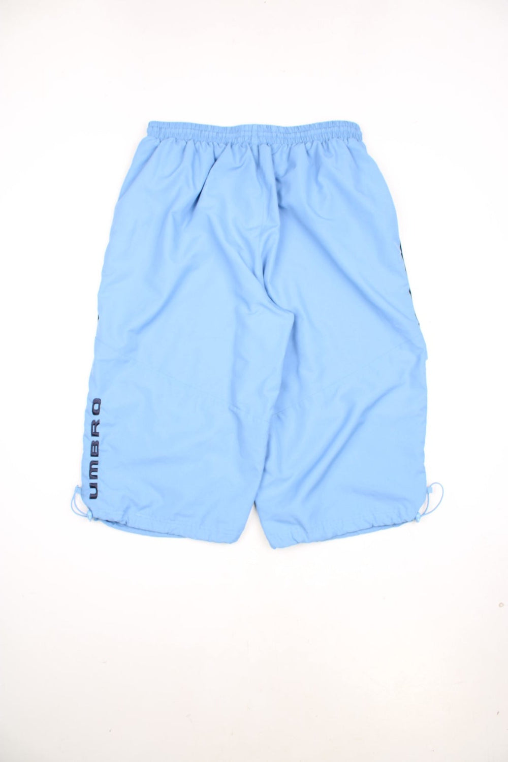 Y2K Umbro Quarter Length Shorts in a blue colourway, has an adjustable waist, mesh netted lining, side pockets, and has the logo embroidered on the front. 