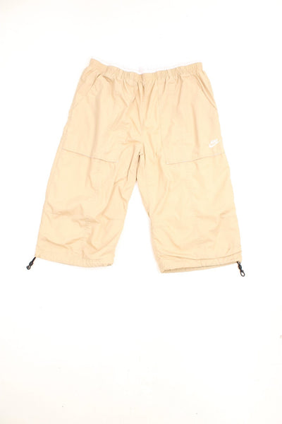 Y2K Nike Quarter Length Shorts in a tanned colourway, pin tucked with big pockets, has an adjustable waist, and the logo embroidered on the front.