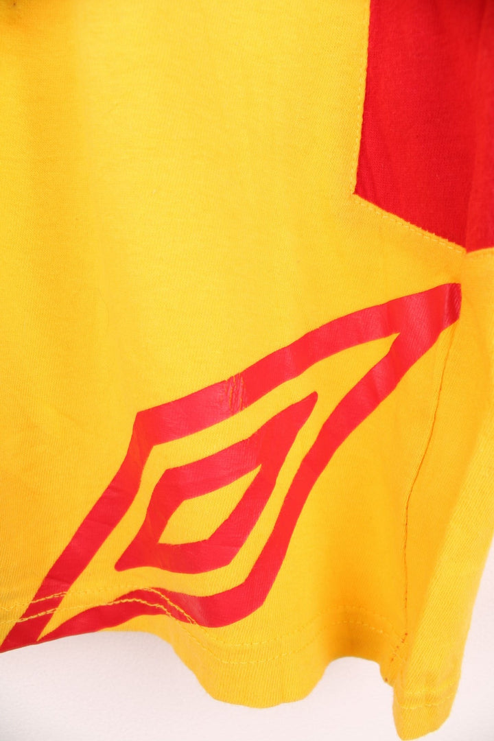 Umbro Spain Football T-Shirt in a yellow and red colourway with the logos printed on the front and on the back is the Spain spell out print.