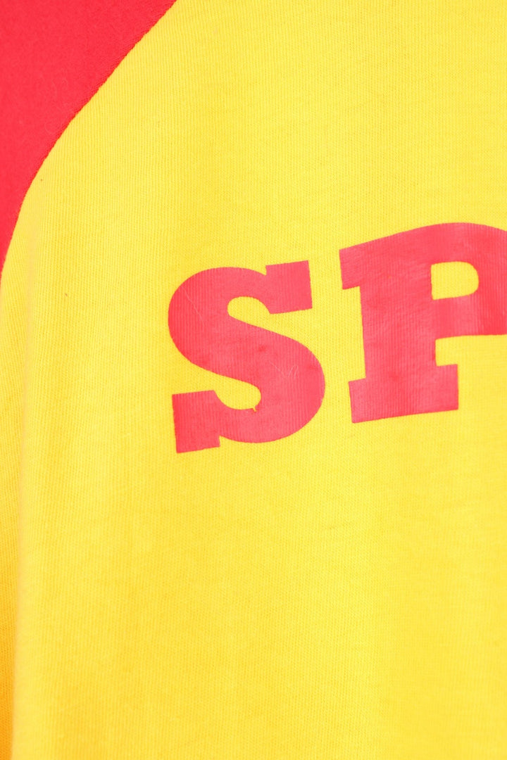 Umbro Spain Football T-Shirt in a yellow and red colourway with the logos printed on the front and on the back is the Spain spell out print.