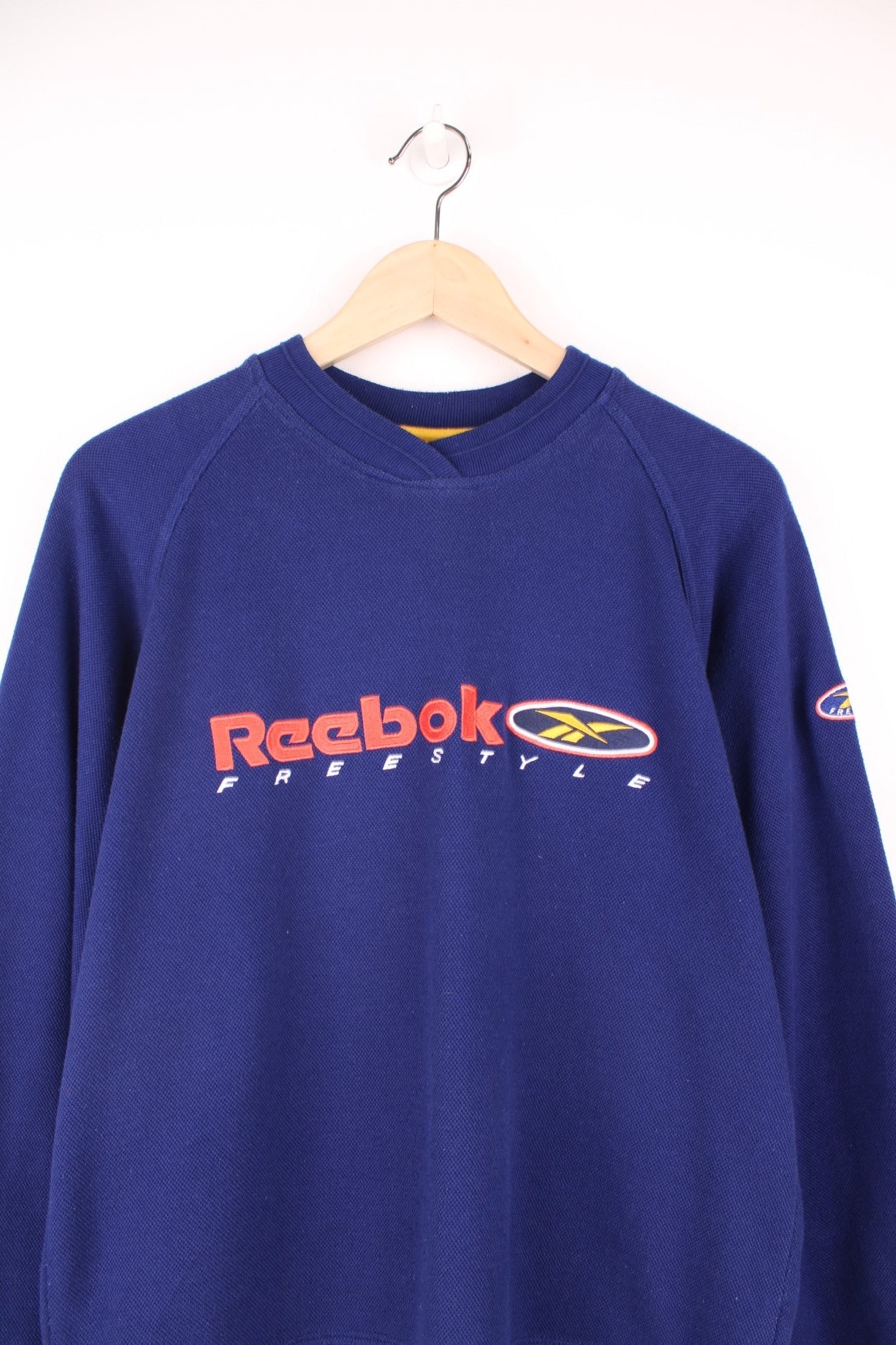 Reebok Freestyle Sweatshirt in a blue colourway with the spell out logo embroidered across the front and on the left sleeve.