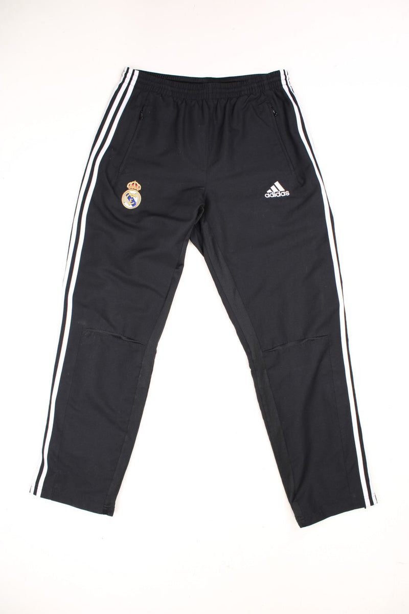 Real Madrid Adidas Tracksuit Bottoms in a black and white colourway, has an elasticated waist with drawstrings, pockets, and the logos embroidered on the front. 