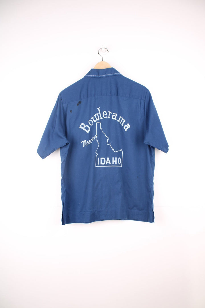 Vintage 70's Bowling Shirt in a blue colourway with western style cross stitching, button up with a dagger collar, has a chest pocket and also has 'Bowlerama, Idaho' graphic printed on the back.