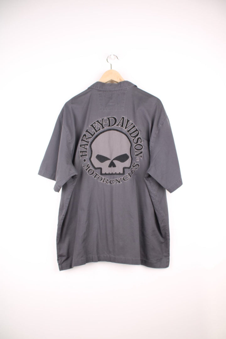 Y2K Harley Davidson Skull Shirt in a grey and black colourway, workwear style, button up with double chest pockets, and has the logo and skull design embroidered on the front and back. 