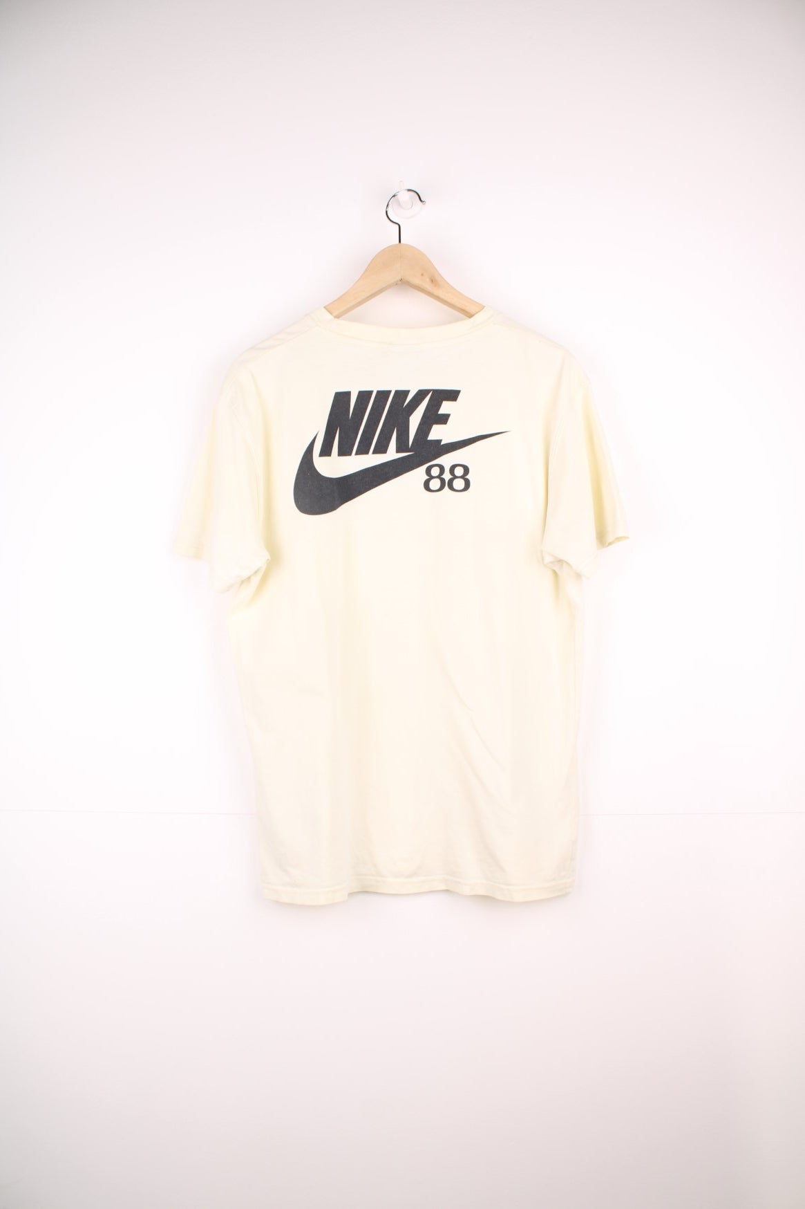 Vintage Nike 1988 Olympic Runners T-Shirt in a pale yellow colourway, has the runners and country flags graphic design printed on the front, as well as the logo and &