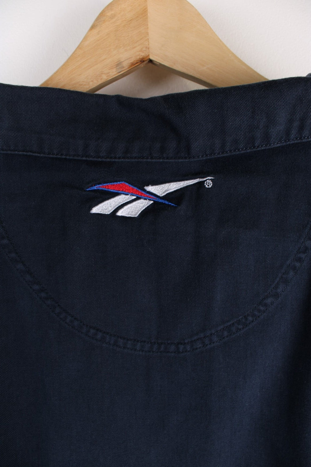 Vintage Reebok Training Top in a navy blue colourway with the logo embroidered on the front, back and on the collar.