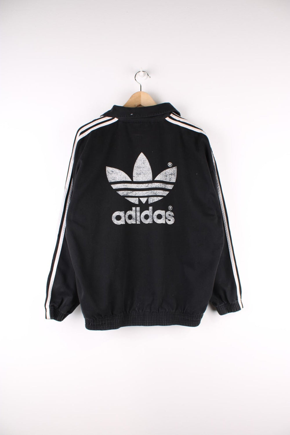 Vintage 90's Adidas Training Top in a black and white colourway, has the iconic three stripes going down the sleeves, and the logo is printed on front and back.