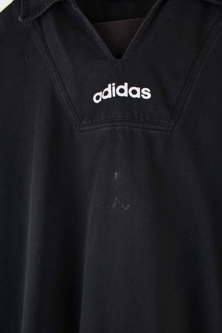 Vintage 90's Adidas Training Top in a black and white colourway, has the iconic three stripes going down the sleeves, and the logo is printed on front and back.