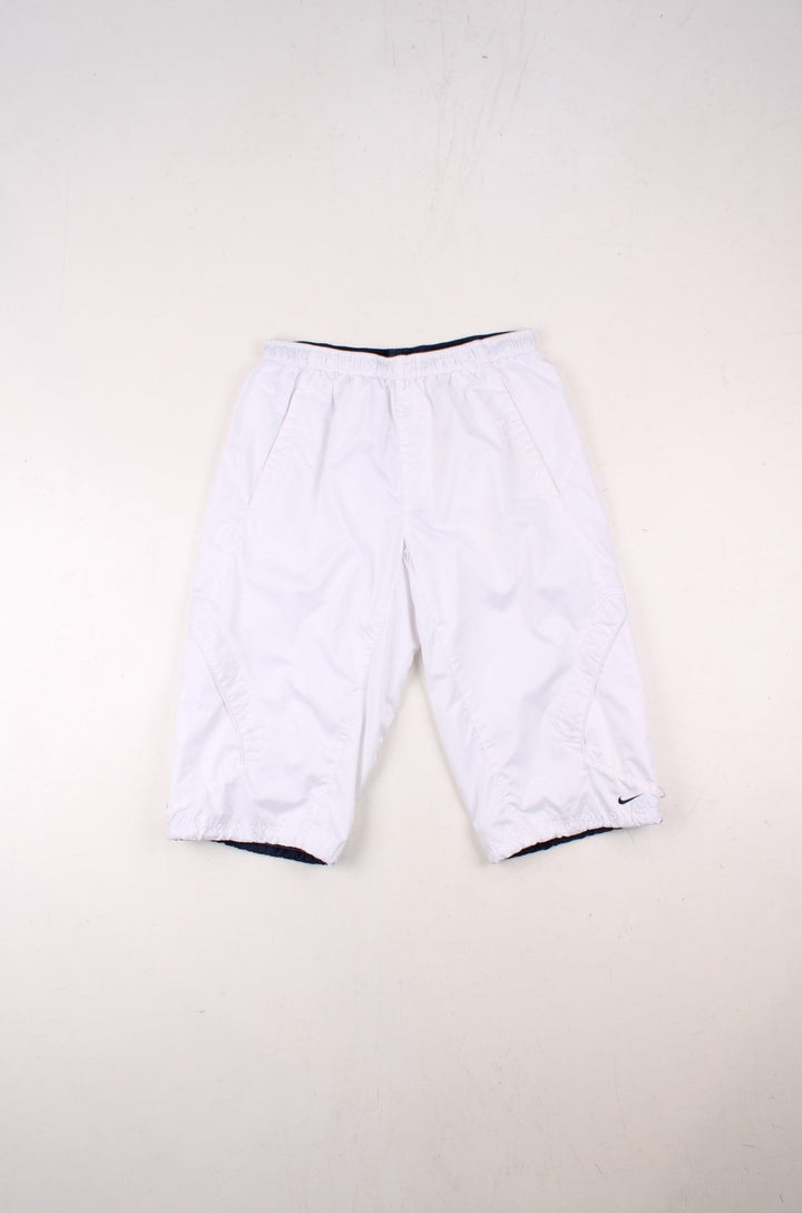 Nike 3/4 length shorts in white with four pockets, an elasticated waist, and an embroidered logo.