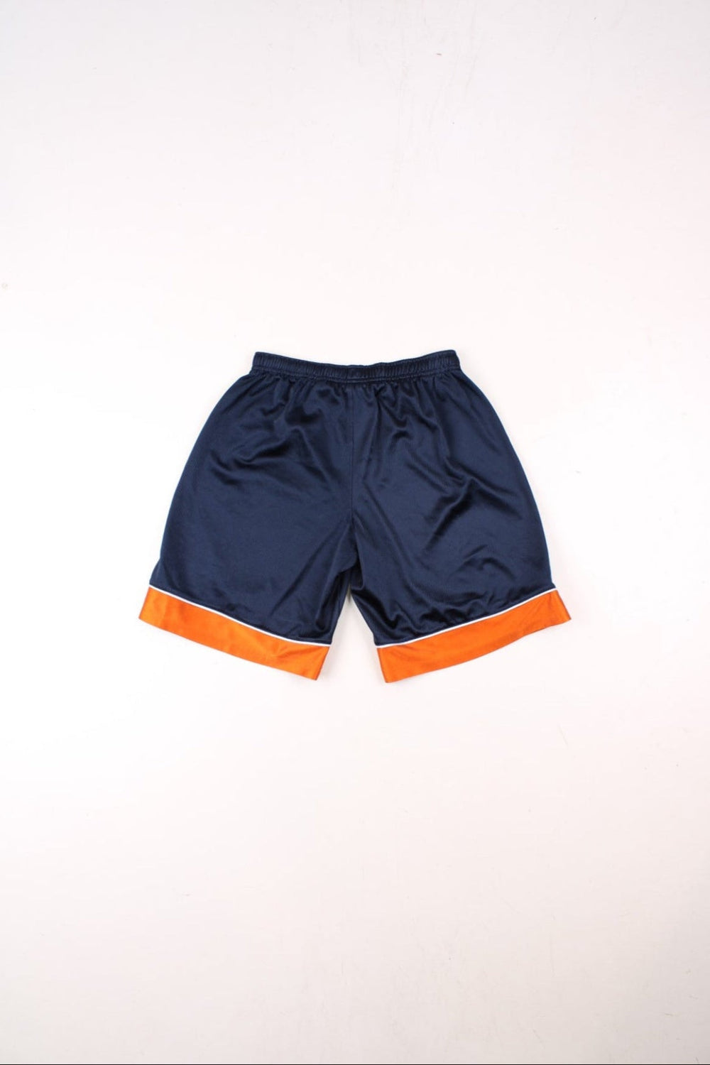 Nike shorts in navy blue and orange with white piping, an elasticated waist, and an embroidered logo on the front.