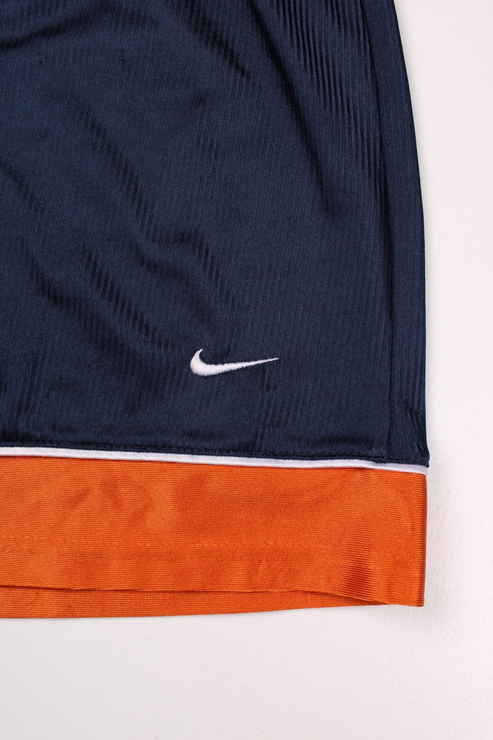 Nike shorts in navy blue and orange with white piping, an elasticated waist, and an embroidered logo on the front.