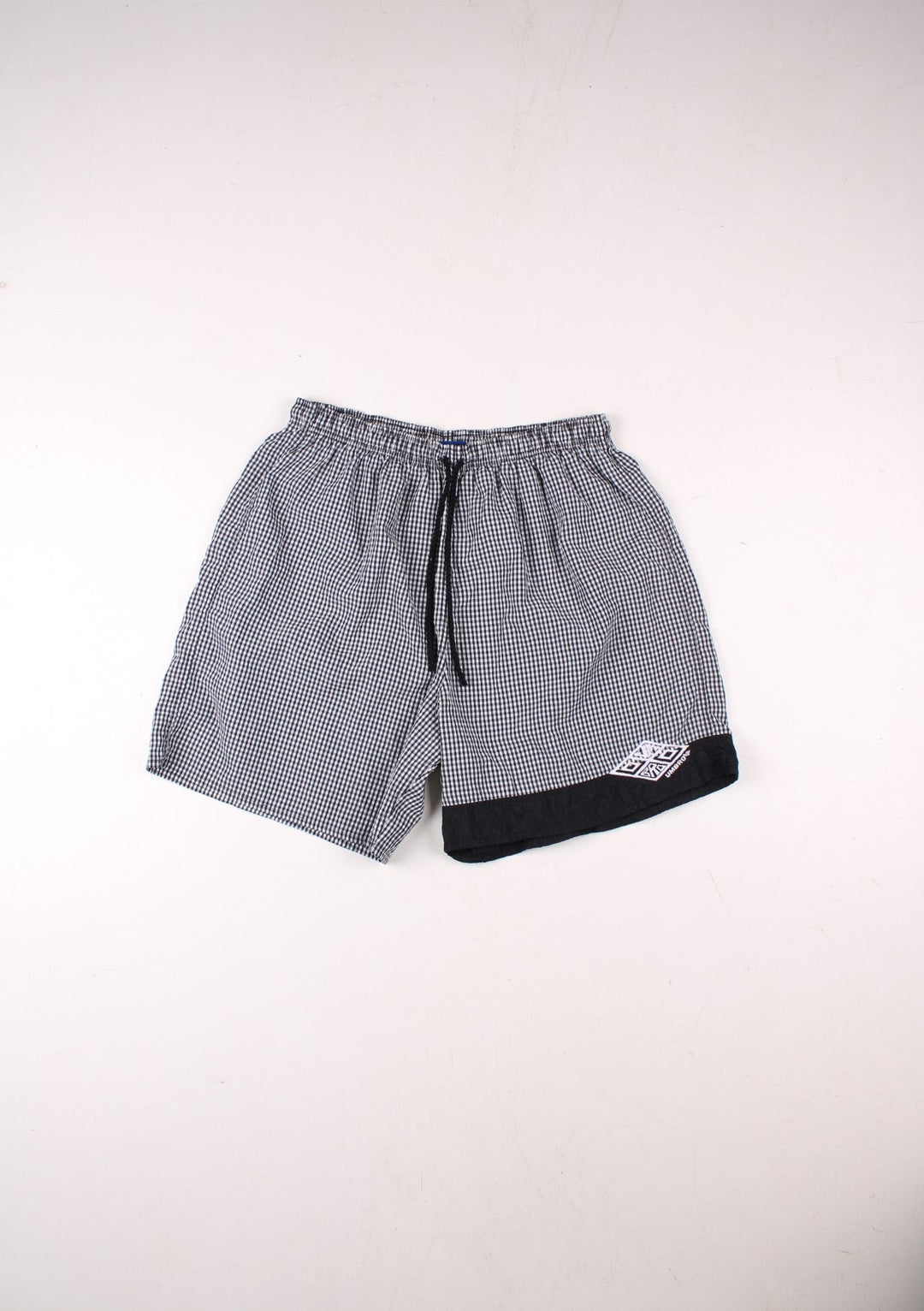 Umbro shorts in black and white gingham with an elasticated waist, drawstring and an embroidered logo.