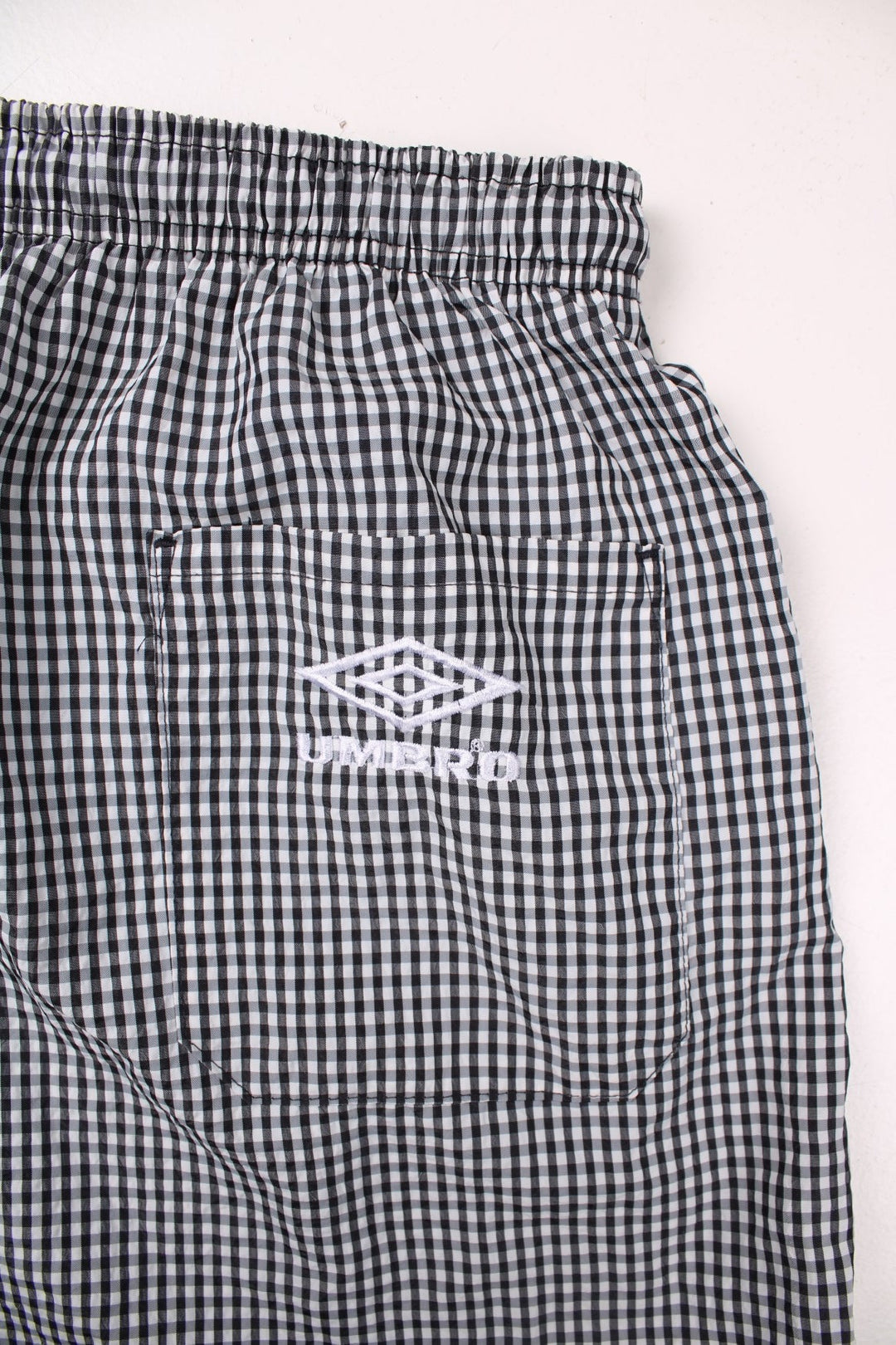 Umbro shorts in black and white gingham with an elasticated waist, drawstring and an embroidered logo.