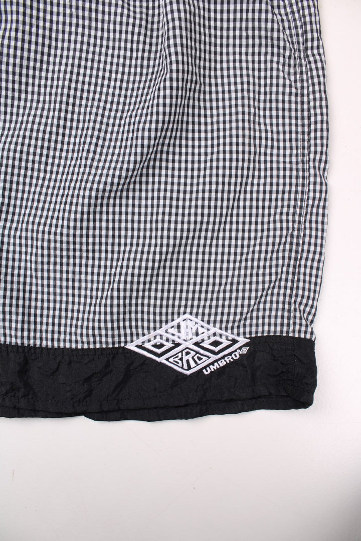 Umbro shorts in black and white gingham with an elasticated waist, drawstring and an embroidered logo.