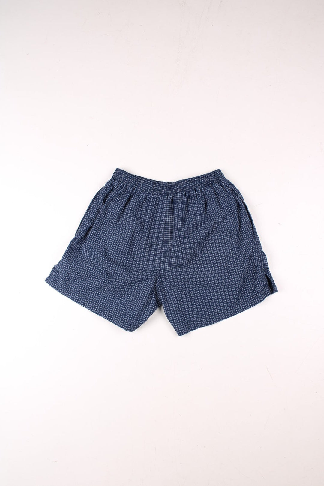 Umbro shorts in navy blue and white check, with an elasticated waist and an embroidered logo.