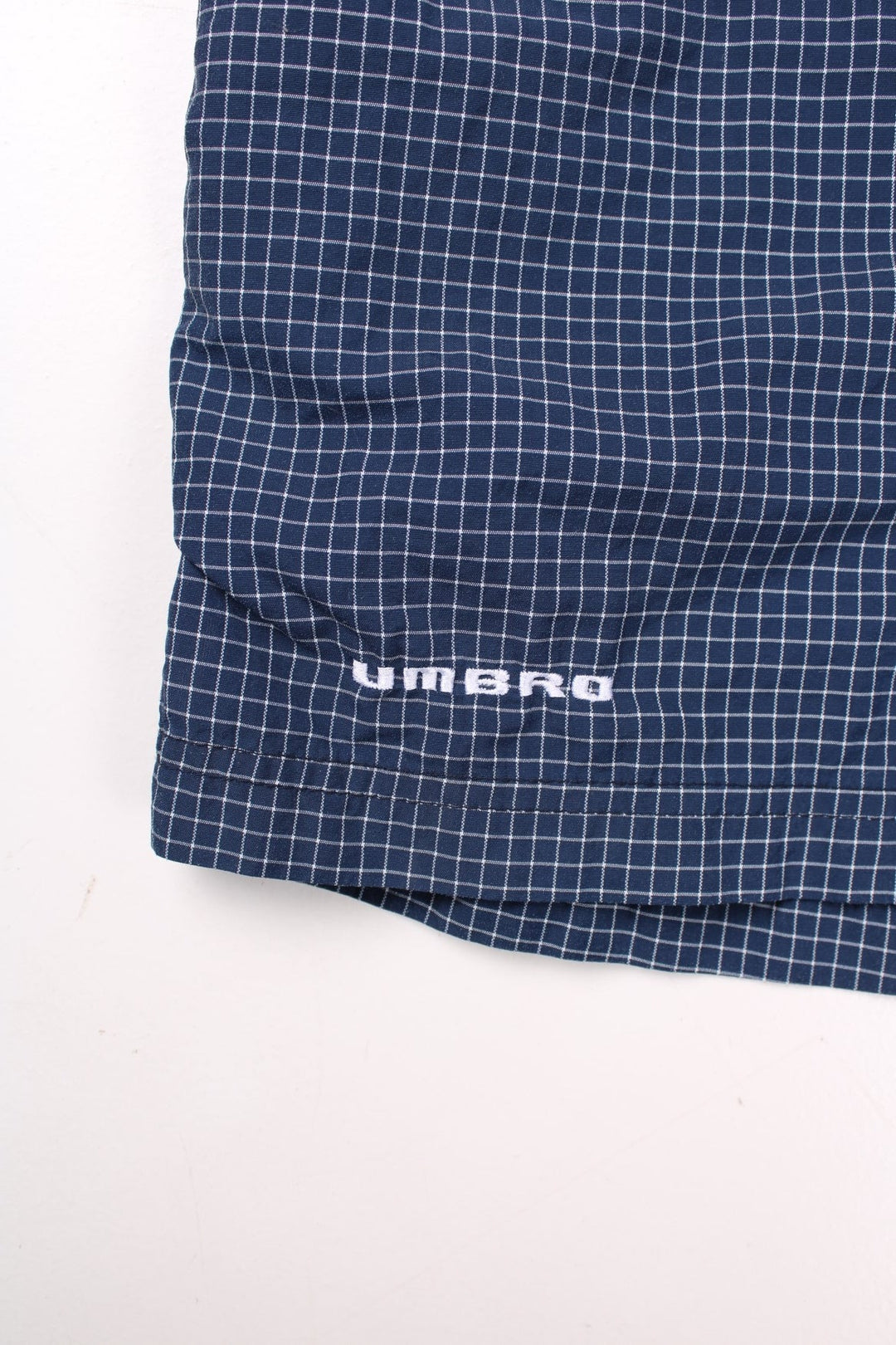 Umbro shorts in navy blue and white check, with an elasticated waist and an embroidered logo.