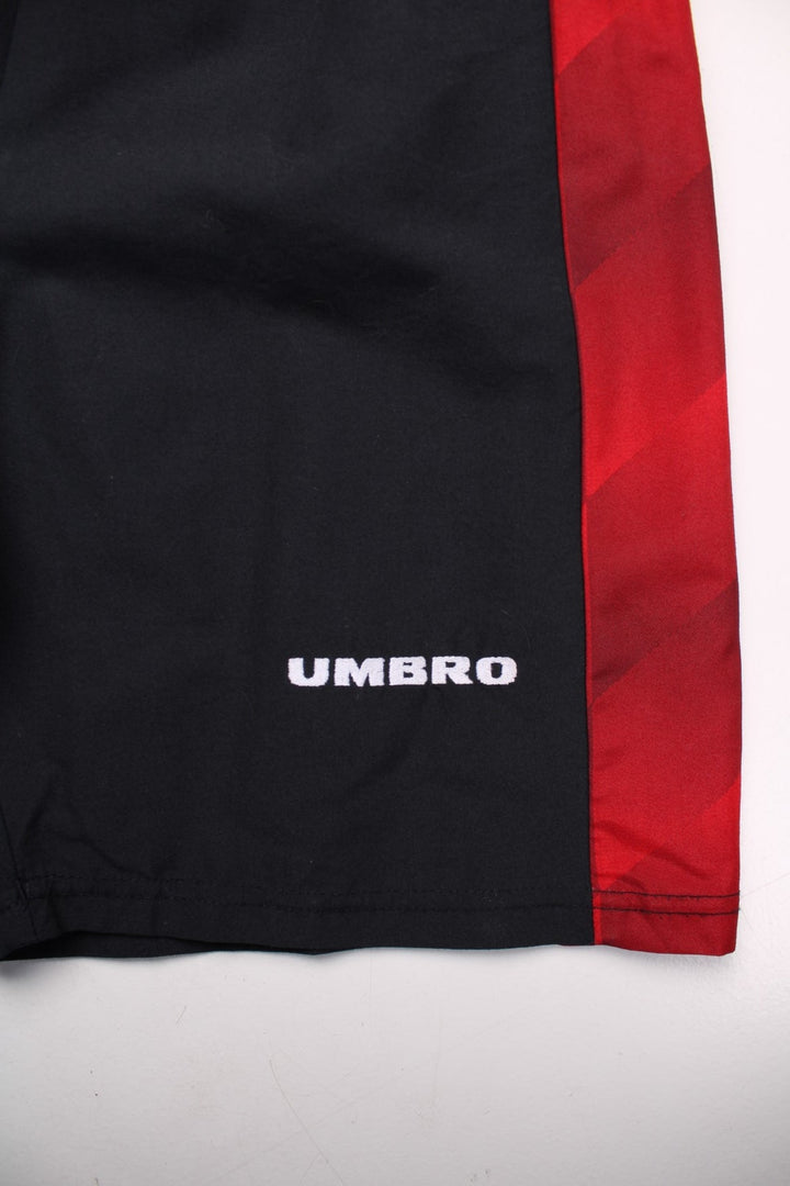 1996-98 Umbro Manchester United home kit shorts in black with red side panels, an elasticated waist, and embroidered Umbro and Man U logos on the front.