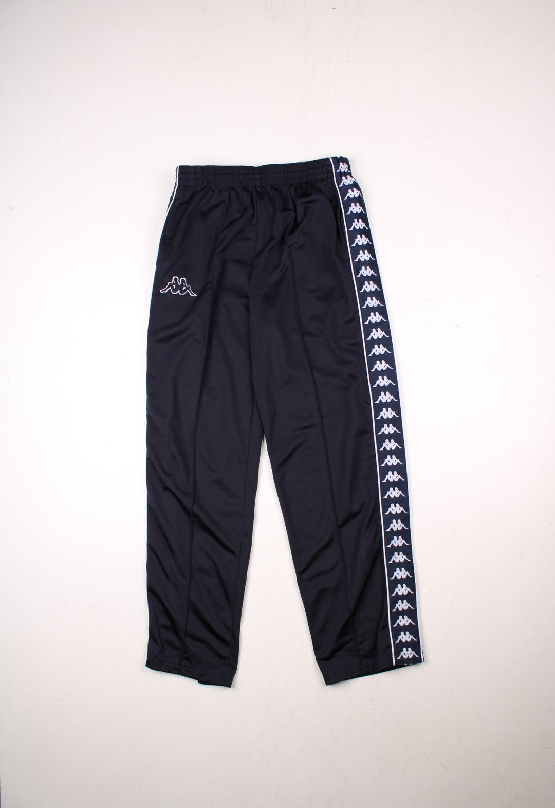 Kappa tracksuit bottoms in navy blue with an elasticated waist, two pockets, logo tape down each side and an embroidered logo on the front.