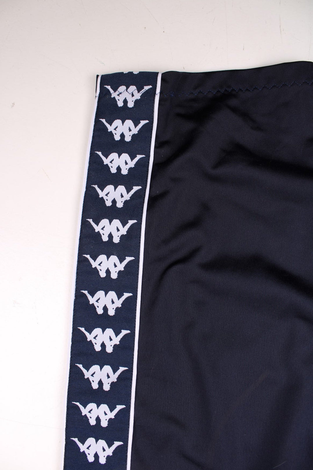 Kappa tracksuit bottoms in navy blue with an elasticated waist, two pockets, logo tape down each side and an embroidered logo on the front.