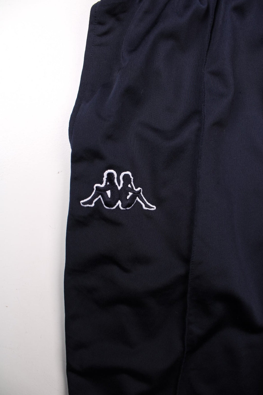 Kappa tracksuit bottoms in navy blue with an elasticated waist, two pockets, logo tape down each side and an embroidered logo on the front.