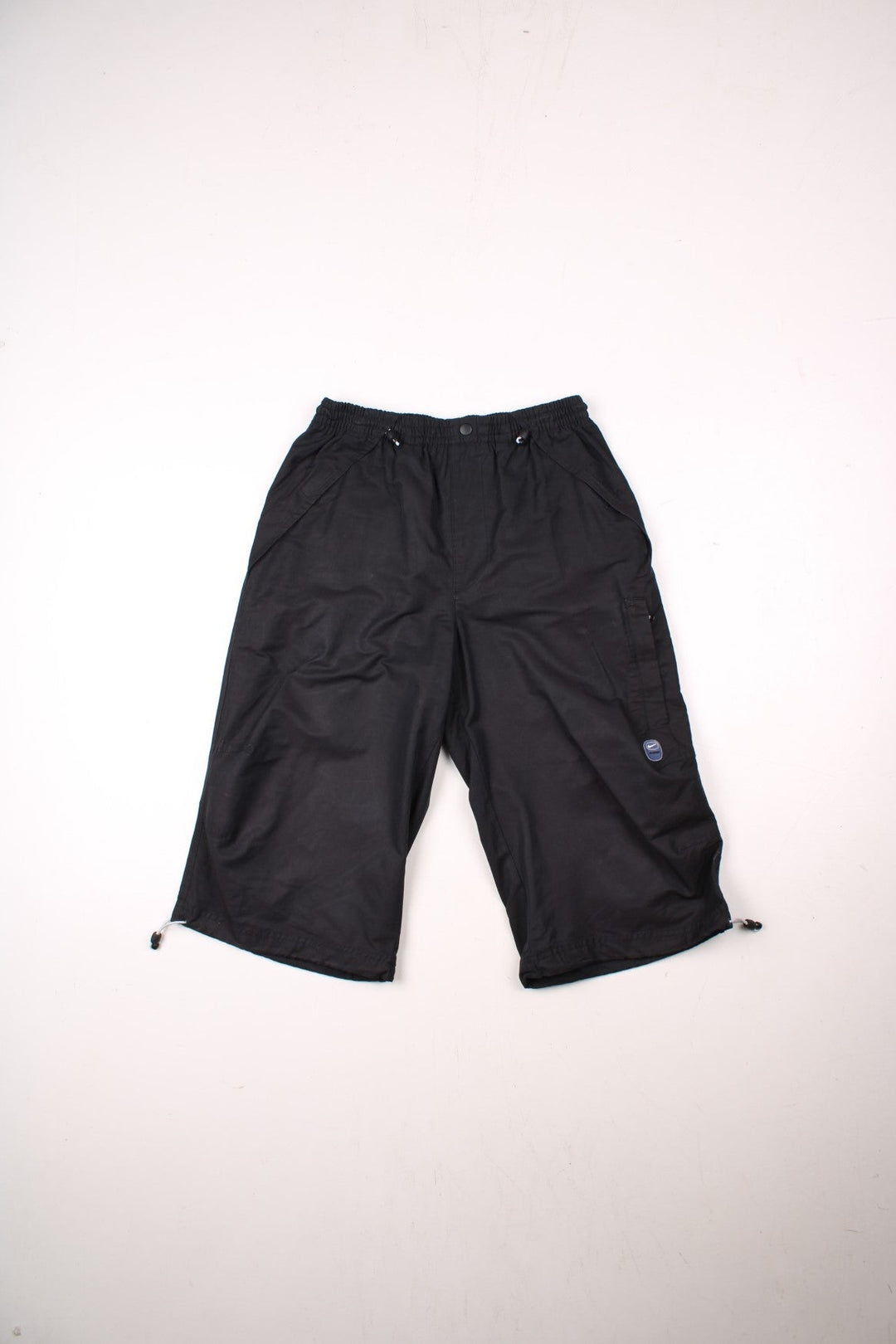 Nike Swoosh shorts in black with an elasticated waist, fake button detail, multiple pockets and several Nike Swoosh logo patches.