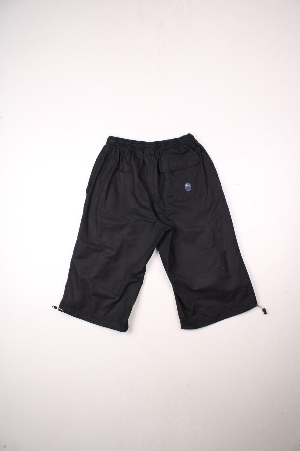 Nike Swoosh shorts in black with an elasticated waist, fake button detail, multiple pockets and several Nike Swoosh logo patches.