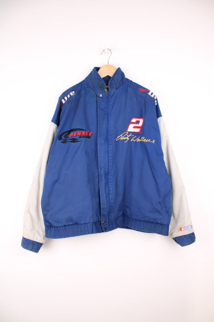 Vintage Rusty Wallace, Penske Racing, zip through NASCAR jacket in blue and grey. Features embroidered sponsor logos, badge on the chest and Rusty Wallace across the back.