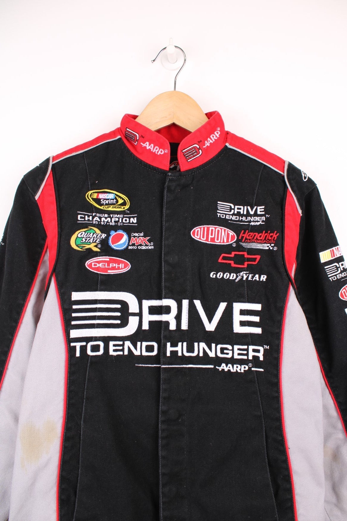 Jeff Gordon Drive To End Hunger NASCAR jacket by Chase Authentics in black, grey and red. Features embroidered sponsor logos on the front and sleeves.