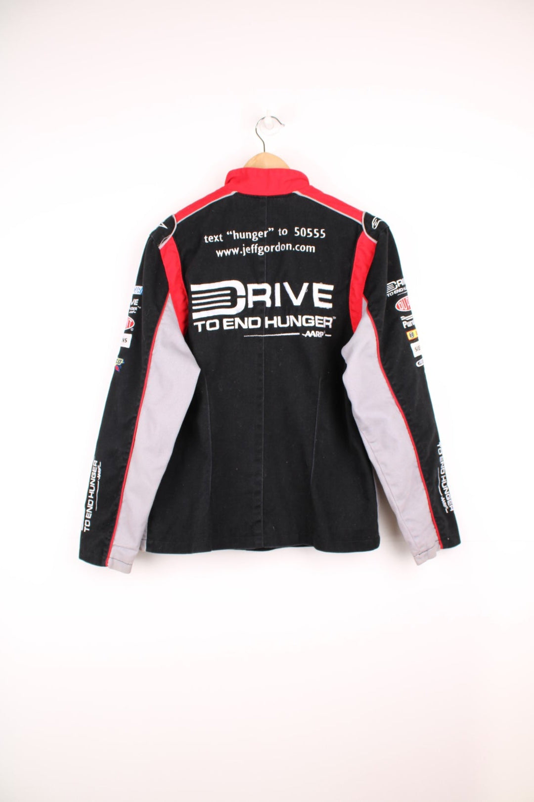 Jeff Gordon Drive To End Hunger NASCAR jacket by Chase Authentics in black, grey and red. Features embroidered sponsor logos on the front and sleeves.