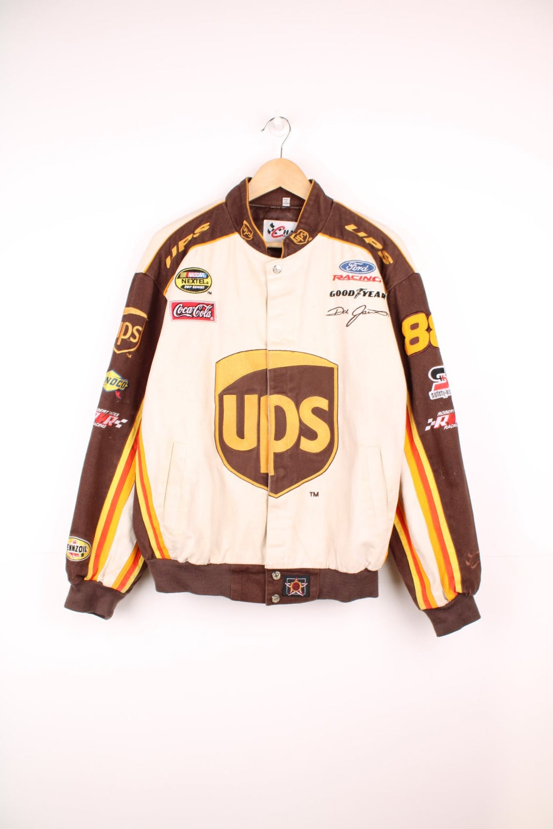 Vintage Dale Jarrett UPS NASCAR jacket by Chase Authentics in brown and orange. Features embroidered sponsor badges all over.  